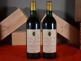 two bottles of wine sitting next to each other on a table