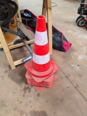 a red and white traffic cone sitting on the ground
