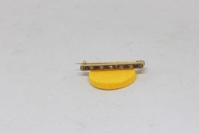 a small yellow piece of jewelry sitting on top of a white surface