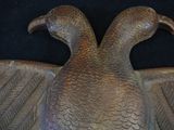 a bronze sculpture of a bird on a black background