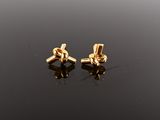une paire de boucles d'oreilles en or sur une surface noire