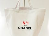 un sac cabas Chanel orné du numéro 1, accroché à un mur