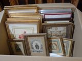 une boîte remplie de photos encadrées et des photos par terre