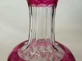 a pink glass vase sitting on a white surface