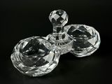 two clear glass candlesticks on a black background