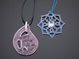 deux pendentifs de couleurs et de formes différentes sur un fond noir