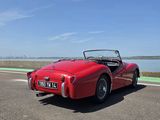 une vieille voiture de sport rouge garée sur le bord de la route
