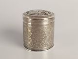 an antique silver metal container with a decorative design on the lid