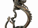 statue of a dragon on a branch with a bird on it ' s back