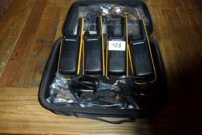Plusieurs téléphones portables se trouvent dans un étui noir posé sur une table en bois
