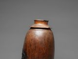 an old wooden vase with a lid sitting on a table