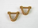 une paire de boucles d'oreilles dorées ornées d'un petit motif triangulaire