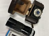 a camera, a camera case, and some other items on a table