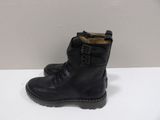 black leather boots with buckles on the side of them on a white surface