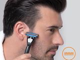 the man is shaving his hair with an electric razor