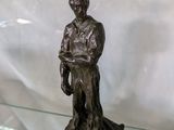 une statue en bronze représentant un homme tenant un livre