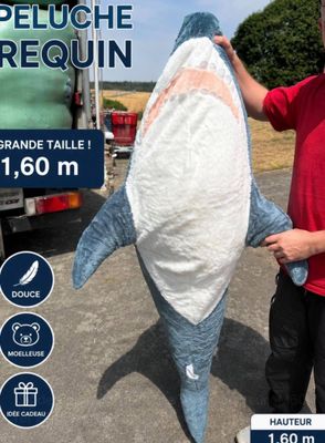 a man holding a large stuffed shark in front of a truck