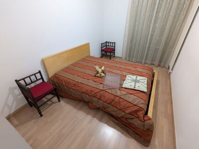 un lit avec une tête de lit en bois et une chaise rouge