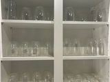 a white cabinet with a bunch of glasses on it
