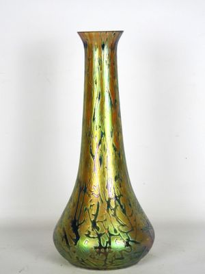 un vase en verre vert posé sur une surface blanche