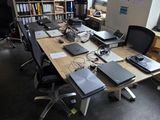 a long table with laptops on it in a large room