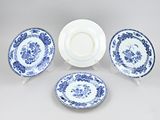 three blue and white plates and a plate with a flower design