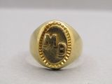 a close up of a gold signet ring with the letter m on it