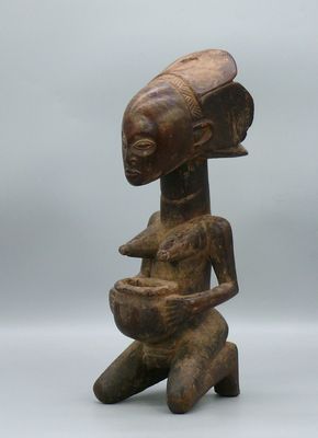 un gros plan sur la statue d'une personne tenant un bol