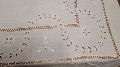 une table recouverte d'une nappe blanche sur laquelle est dessinée une croix