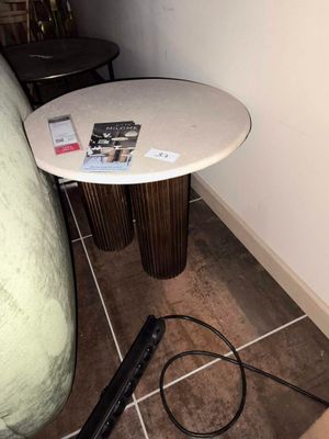 une petite table sur laquelle se trouve un magazine, à côté d'une chaise