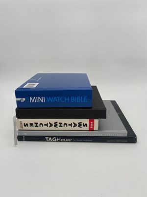 trois livres empilés sur une surface blanche