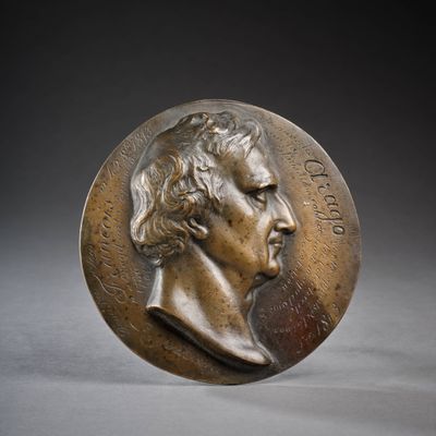une image représentant une médaille de bronze sur laquelle figure le visage d'un homme