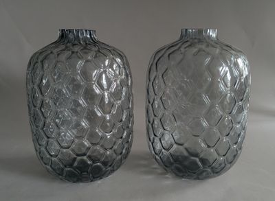 two glass vases sitting next to each other on a table