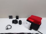 a camera, a lens, a camera case, and a camera strap on a white table