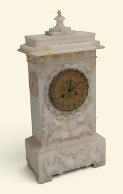 une horloge blanche avec un cadran doré, posée sur un socle