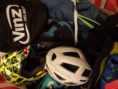 a pile of sports gear and a helmet on a bed