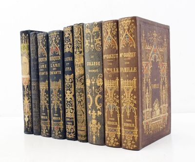 plusieurs vieux livres sont alignés sur une surface blanche
