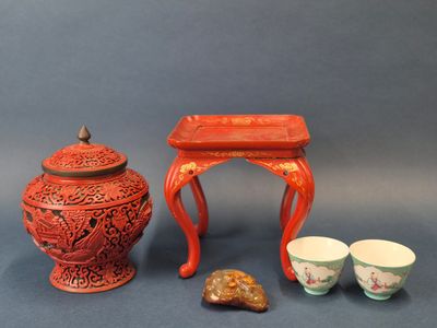une petite table avec deux tasses et un petit vase