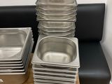many trays of food sitting on a table next to a window