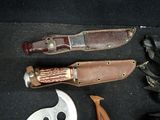 a knife, a knife sheath, and other tools laid out on the floor