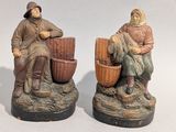 deux figurines d'un homme et d'une femme assis sur un rocher