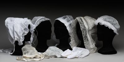 trois mannequins noirs dont la tête est recouverte de dentelle blanche