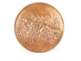 a bronze coin with a bird on it on a white surface