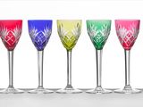 quatre verres à vin de couleurs différentes sont alignés en rangée