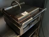 a grill that is sitting in the corner of a kitchen