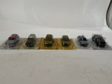several toy cars are lined up in plastic bags on a white surface
