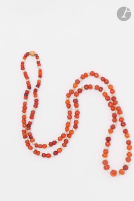 un collier de perles orange muni d'un fermoir doré, sur fond blanc
