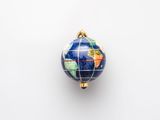 a blue and gold globe ornament hanging on a white wall