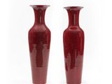 deux vases rouges posés côte à côte sur une surface blanche