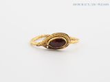 a close up of a gold ring with a red stone in it